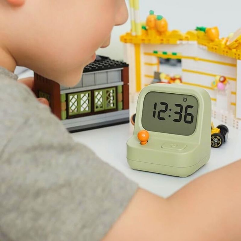 Réveil vert sur bureau avec enfant au petit-déjeuner – TopRéveil