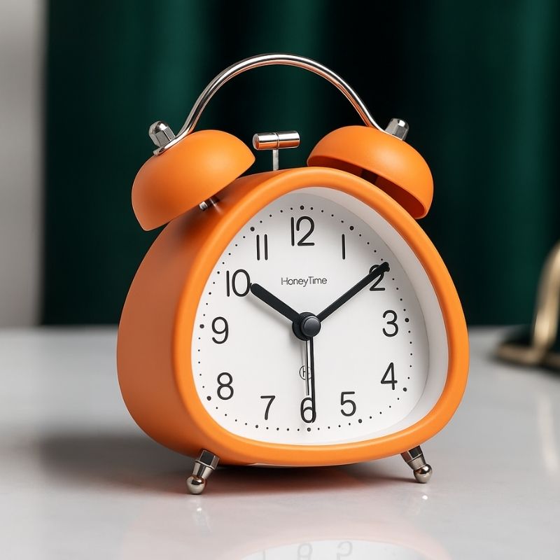 Réveil orange vintage en métal 12 cm posé sur une table moderne