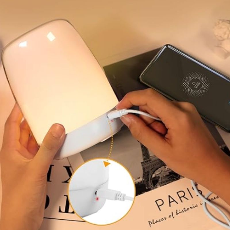 Réveil lampe blanche posé sur une table de nuit