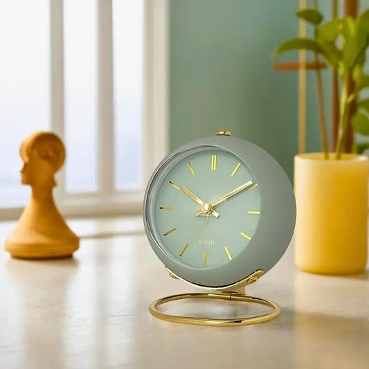 Réveil blanc et doré posé sur une table moderne